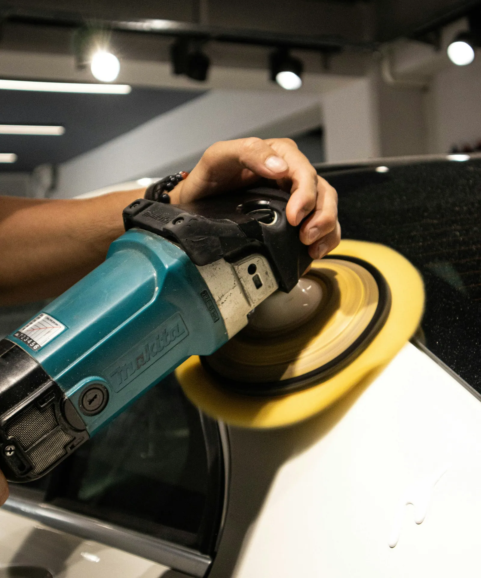 Rotary polisher finishing a car panel