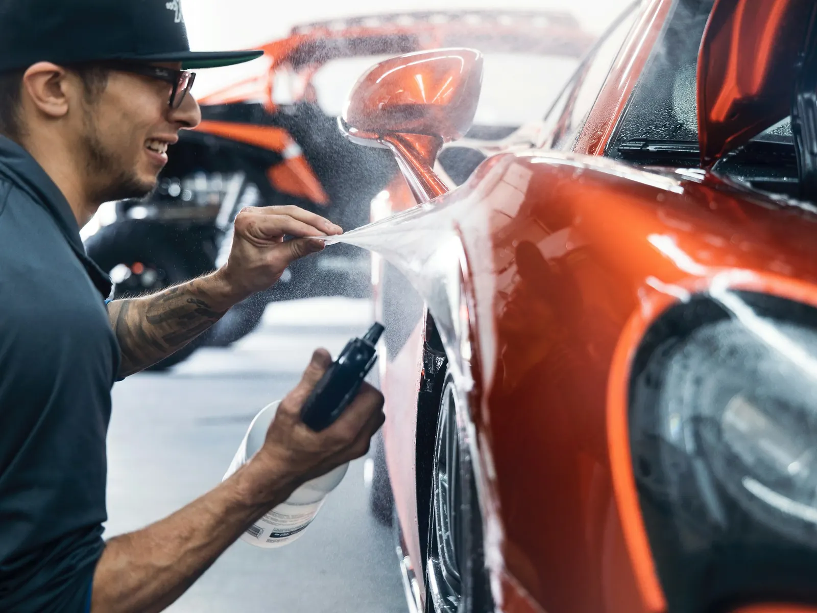 Technician preparing a car panel for refinishing