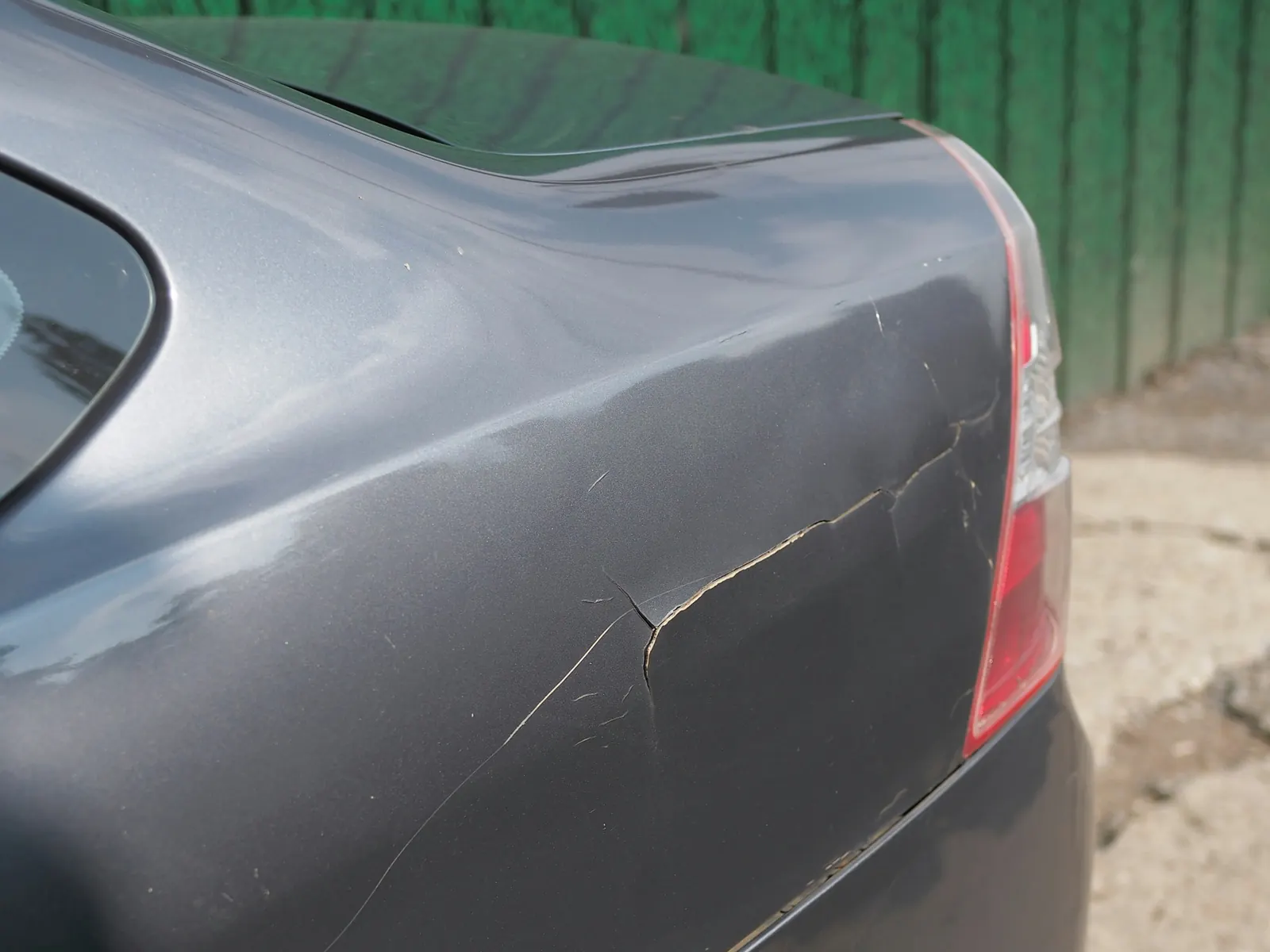 Damaged car fender with cracked paint